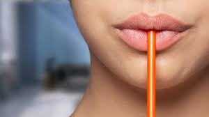 woman drinking out of a straw